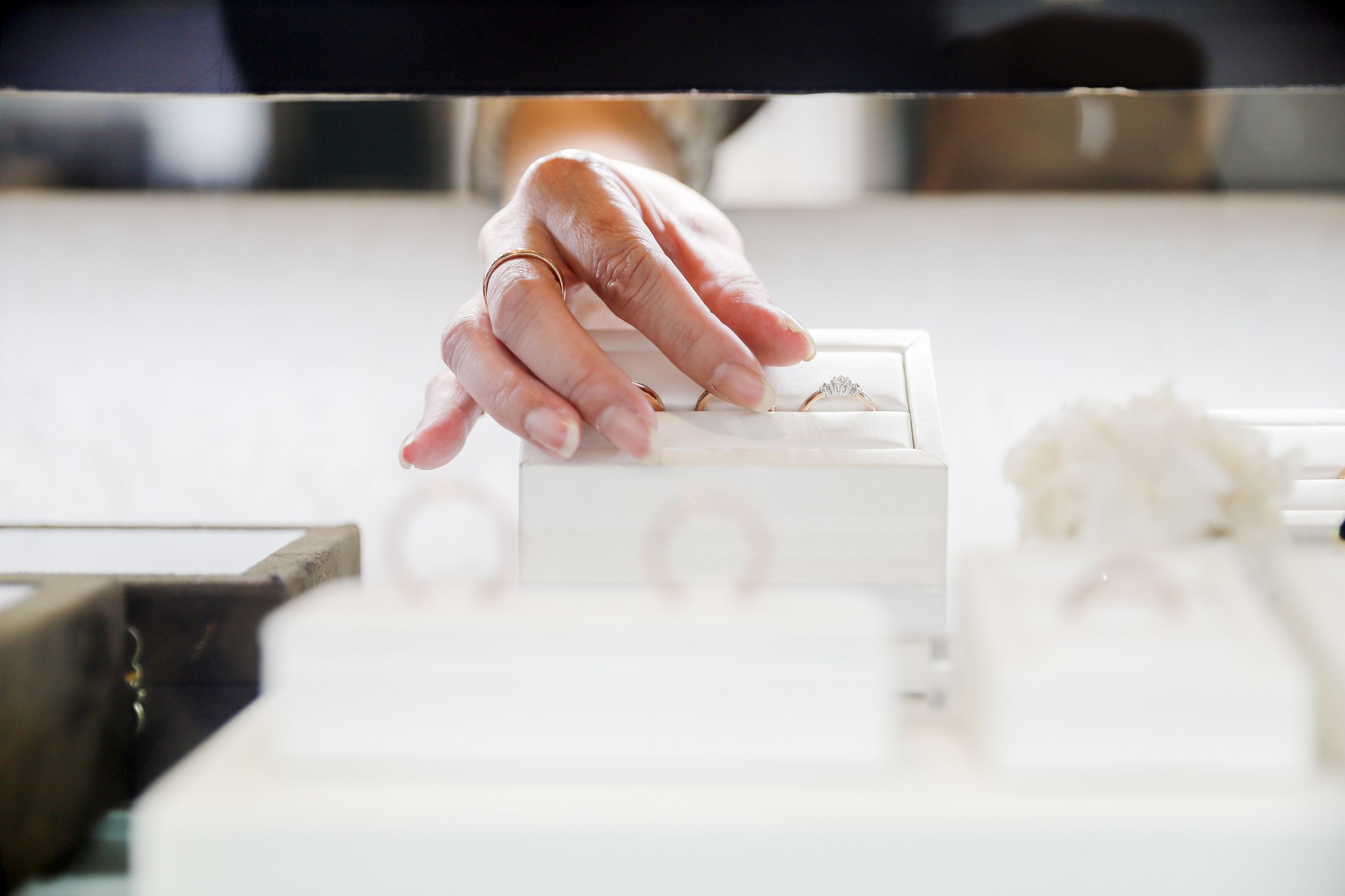 The female clerk in the jewelry store took out the jewelry on the counter and prepared to introduce it to the customers.